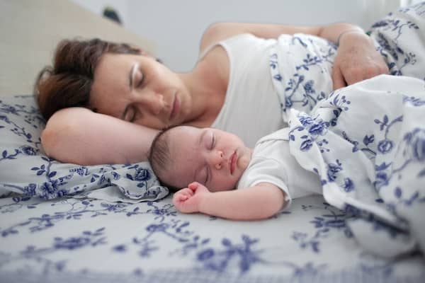 Young mother sleeps with her baby