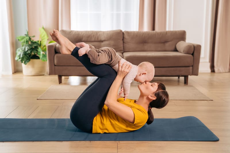 Pilates mom practicing with her toddler baby