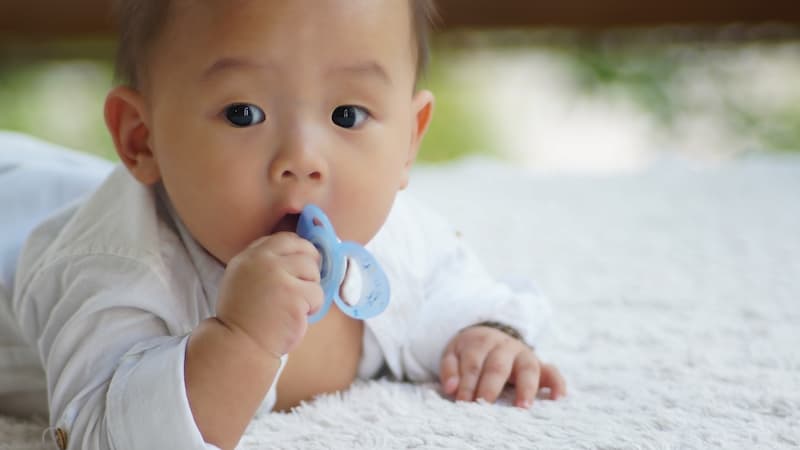 Portrait of cute baby boy with pacifier on mouth