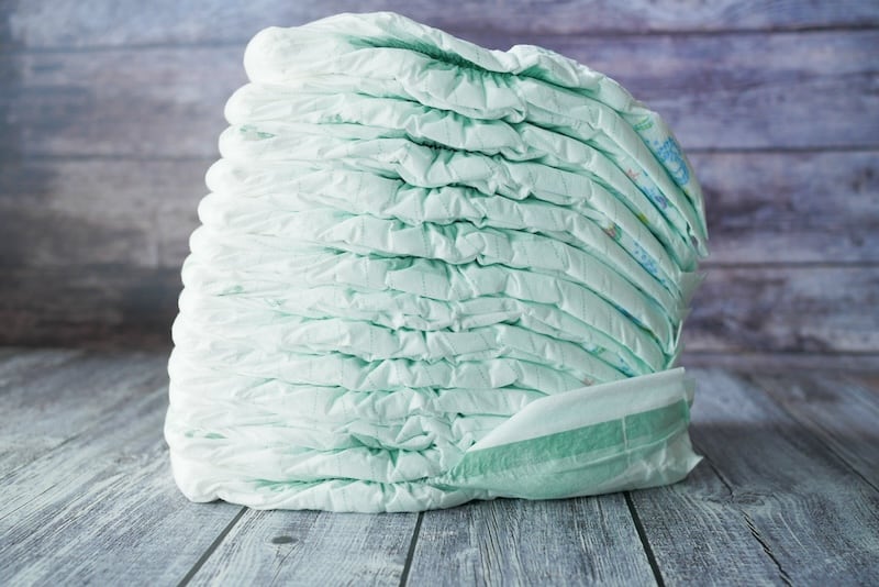 A stack of diapers on a wooden table.