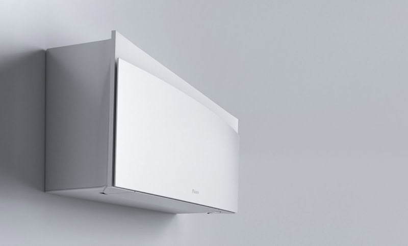 Minimalist white wall-mounted air conditioning unit against a light gray wall, ensuring comfortable temperatures that positively affect the environment for babies.