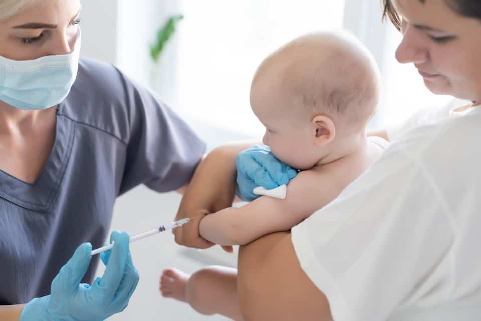 Doctor makes a vaccination on a calm baby