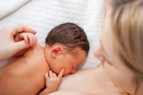 Newborn baby breastfeeding after birth