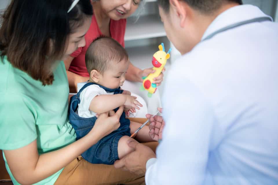 A little child taking an injection from the doctor