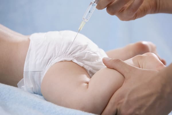 Female doctor injecting baby, close-up